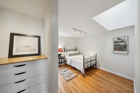 a bedroom with bed and paintings on the wall
