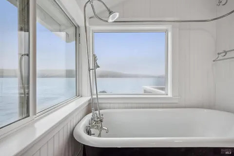 a bathroom with bathtub and window