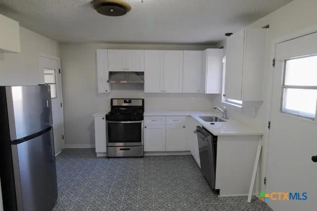 a kitchen with a refrigerator and a stove