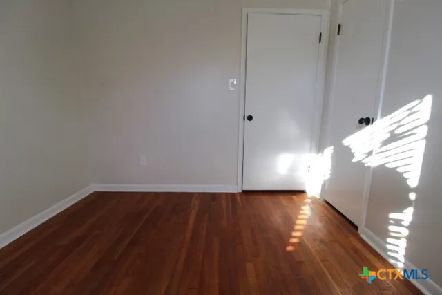 a view of an empty room and wooden floor