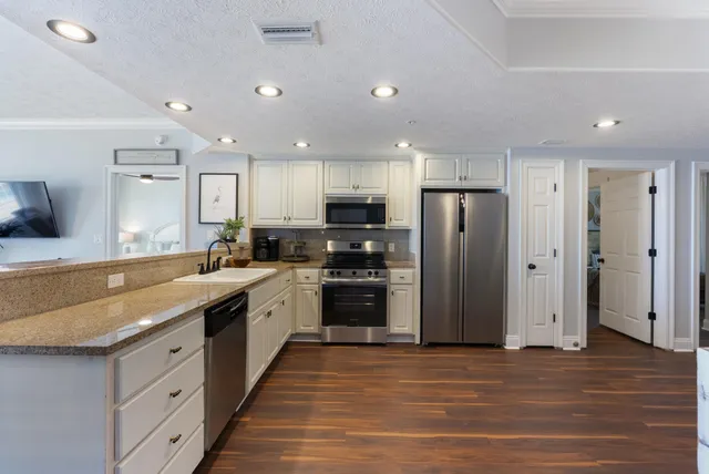 a kitchen with white cabinets and stainless steel appliances