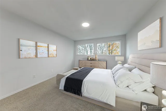 a large bedroom with a bed and wooden floor