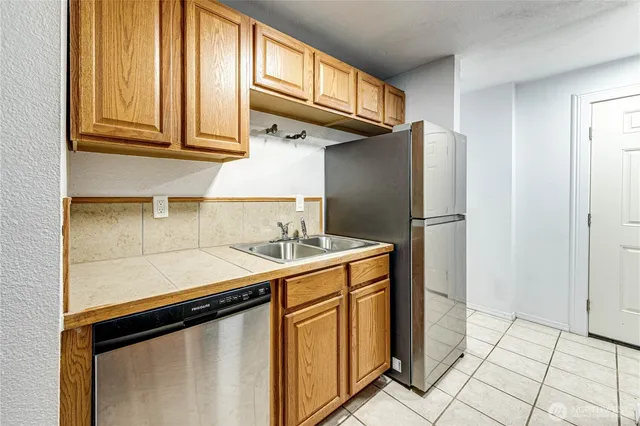 a kitchen with stainless steel appliances granite countertop a refrigerator and a stove