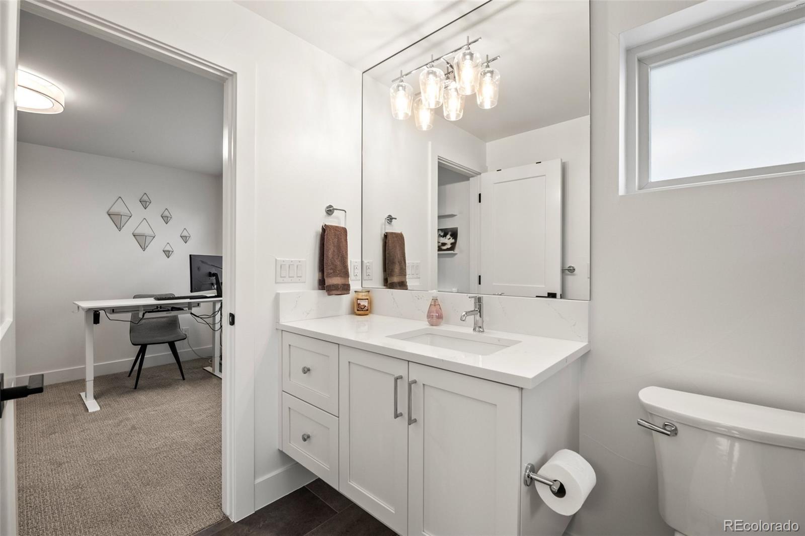 3612 Vallejo Street Denver, CO 80211 - Photo 26 of 50 a spacious bathroom with a toilet sink and mirror