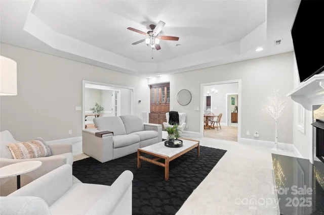 a living room with furniture a fireplace and a chandelier