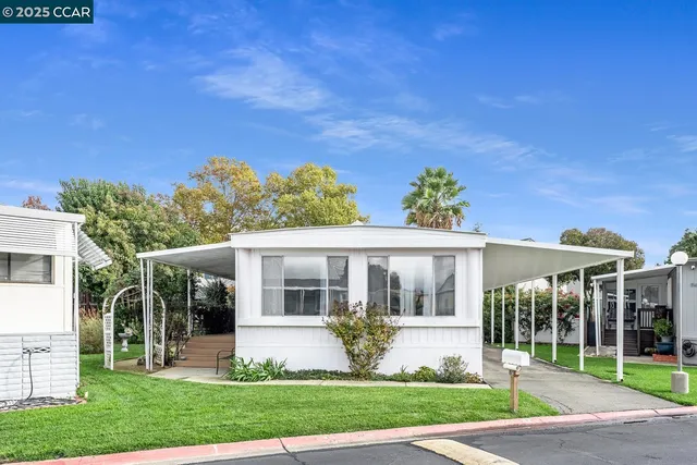a front view of a house with a garden and plants