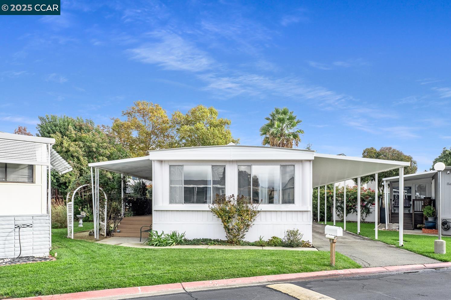 a front view of a house with a garden and plants