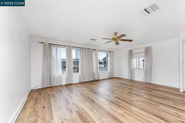 a view of a livingroom with a ceiling fan and wooden floor