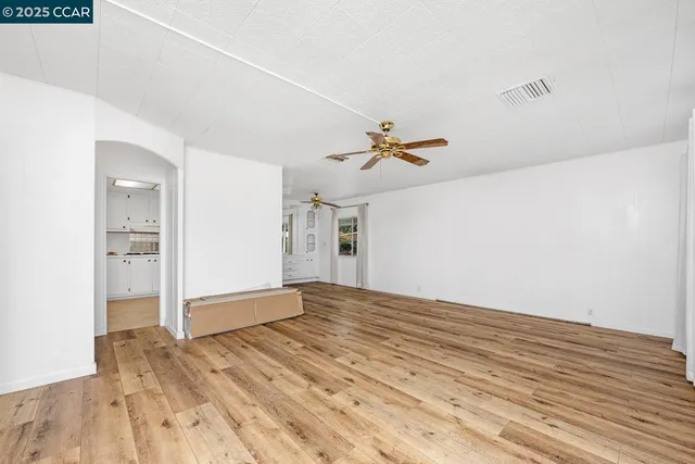 a view of a kitchen with wooden floor and a ceiling fan
