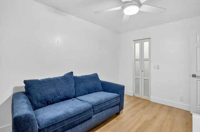 a view of a livingroom with wooden floor and furniture