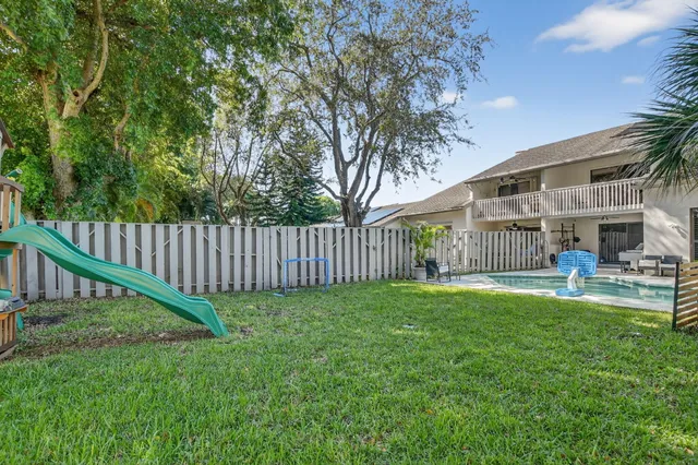an aerial view of residential house with outdoor space and trees all around