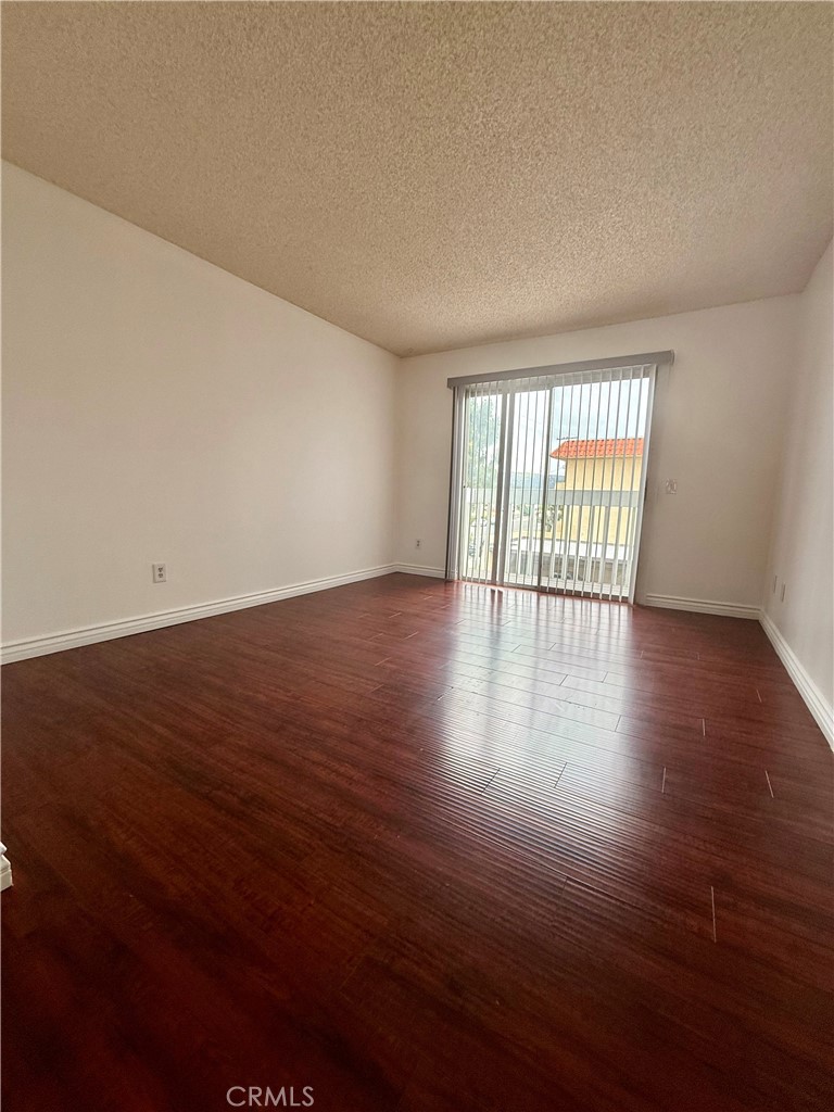 10700 Colima Road, Unit 914 Whittier, CA 90604 - Photo 8 of 14 a view of an empty room with wooden floor and a window
