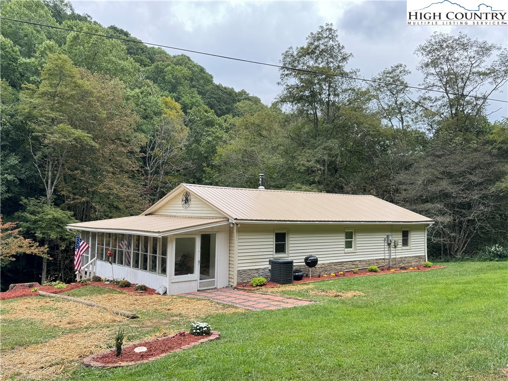 321 Skin Camp Creek Road Todd, NC 28684 - Photo 18 of 29 a front view of a house with a yard table and chairs