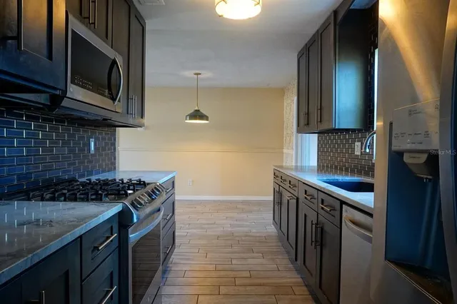 a kitchen with granite countertop a sink stainless steel appliances a counter space and cabinets