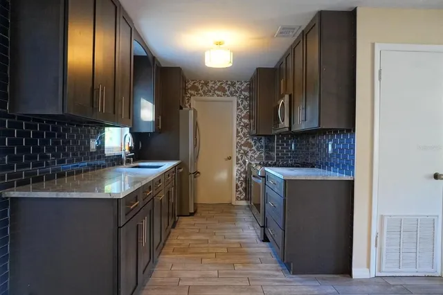 a kitchen with a sink refrigerator and cabinets