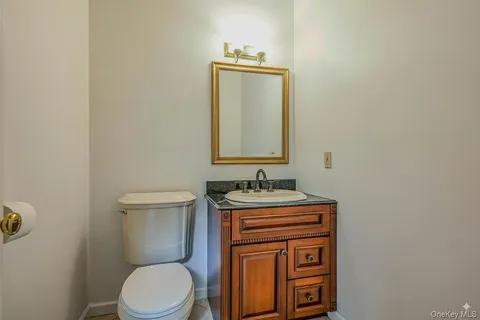 a bathroom with a toilet a sink and mirror