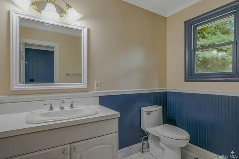 a bathroom with a granite countertop bathtub sink vanity mirror and toilet