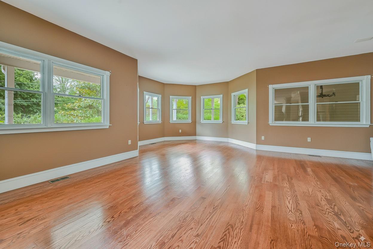4 Skunk Hollow Road Huntington, NY 11743 - Photo 4 of 35 a view of an empty room with wooden floor and a window