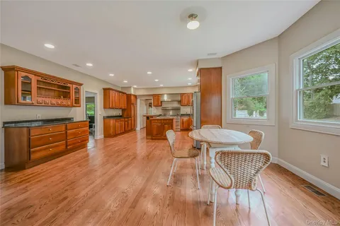 a living room with furniture and kitchen view with wooden floor