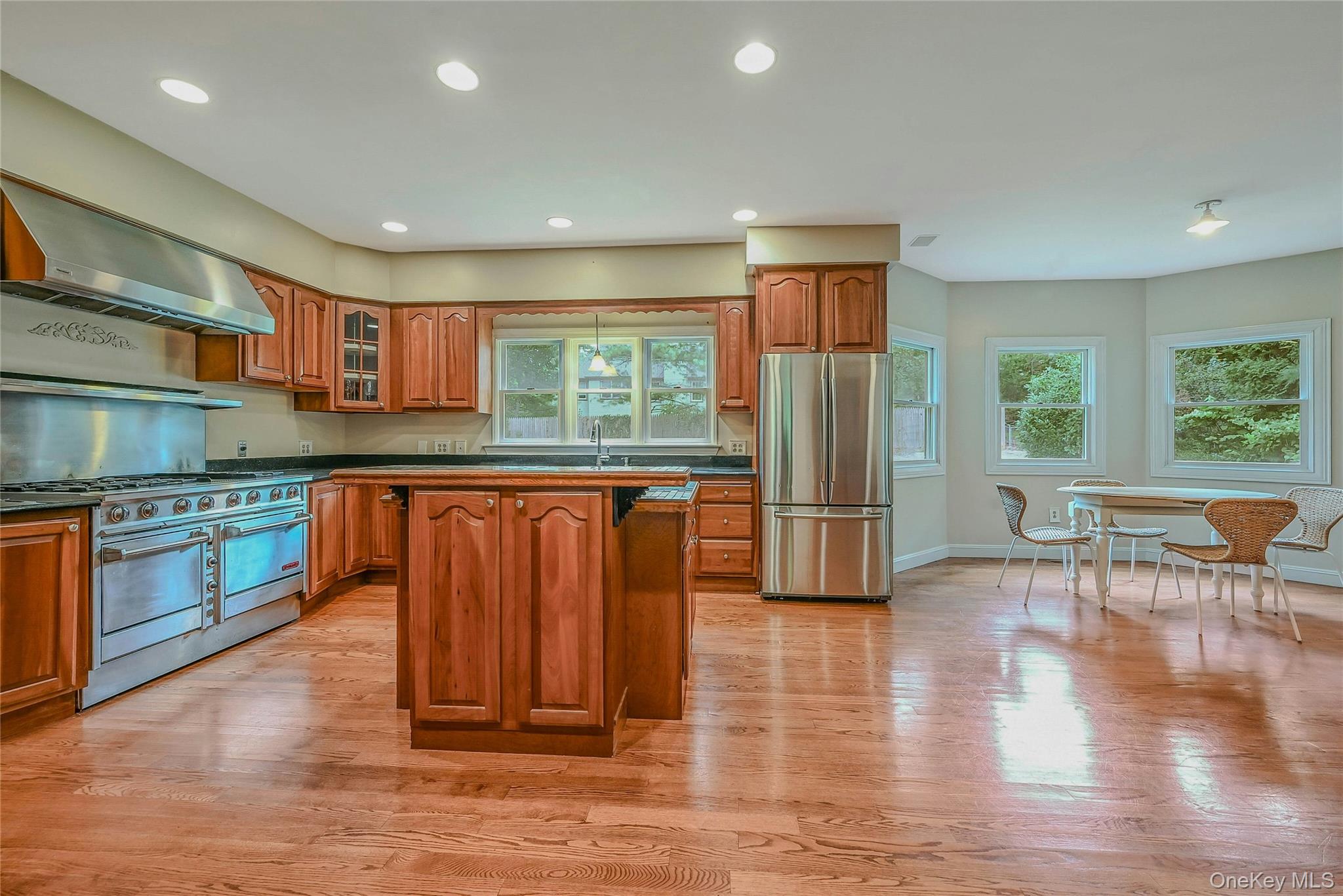4 Skunk Hollow Road Huntington, NY 11743 - Photo 10 of 35 a kitchen with stainless steel appliances granite countertop a refrigerator a stove top oven and a dishwasher with wooden floor