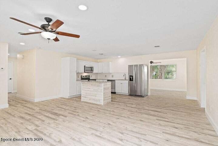 15 Devonshire Drive Melbourne, FL 32901 - Photo 2 of 5 a view of a kitchen with wooden floor and a ceiling fan