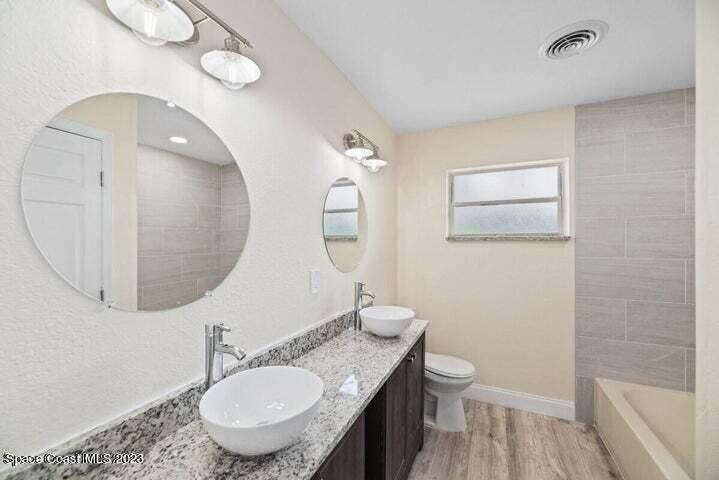 15 Devonshire Drive Melbourne, FL 32901 - Photo 4 of 5 a bathroom with a toilet a sink and mirror