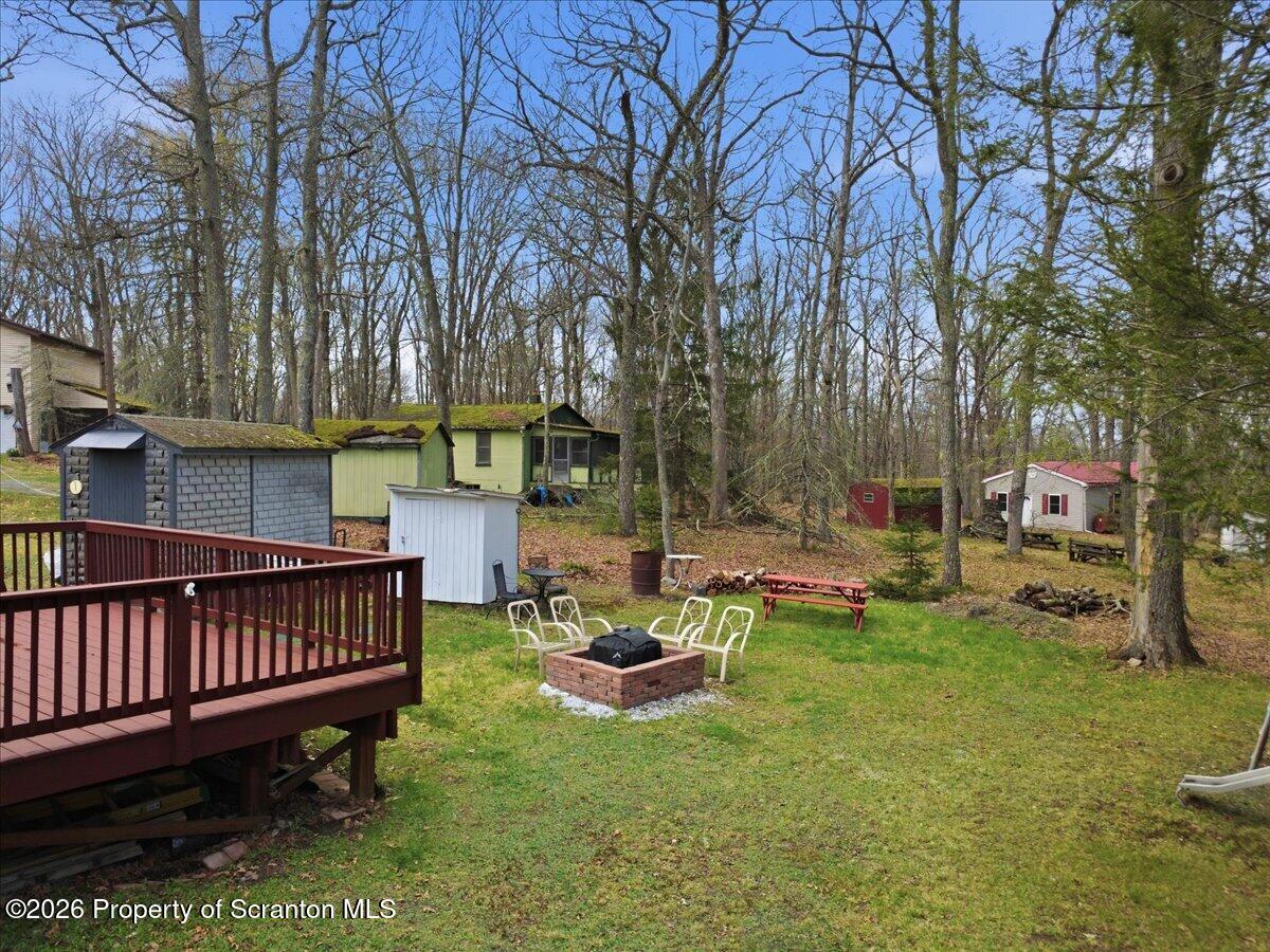 113 Stoney Hill Road Dingmans Ferry, PA 18328 - Photo 45 of 65 a view of a chair and table in backyard of the house