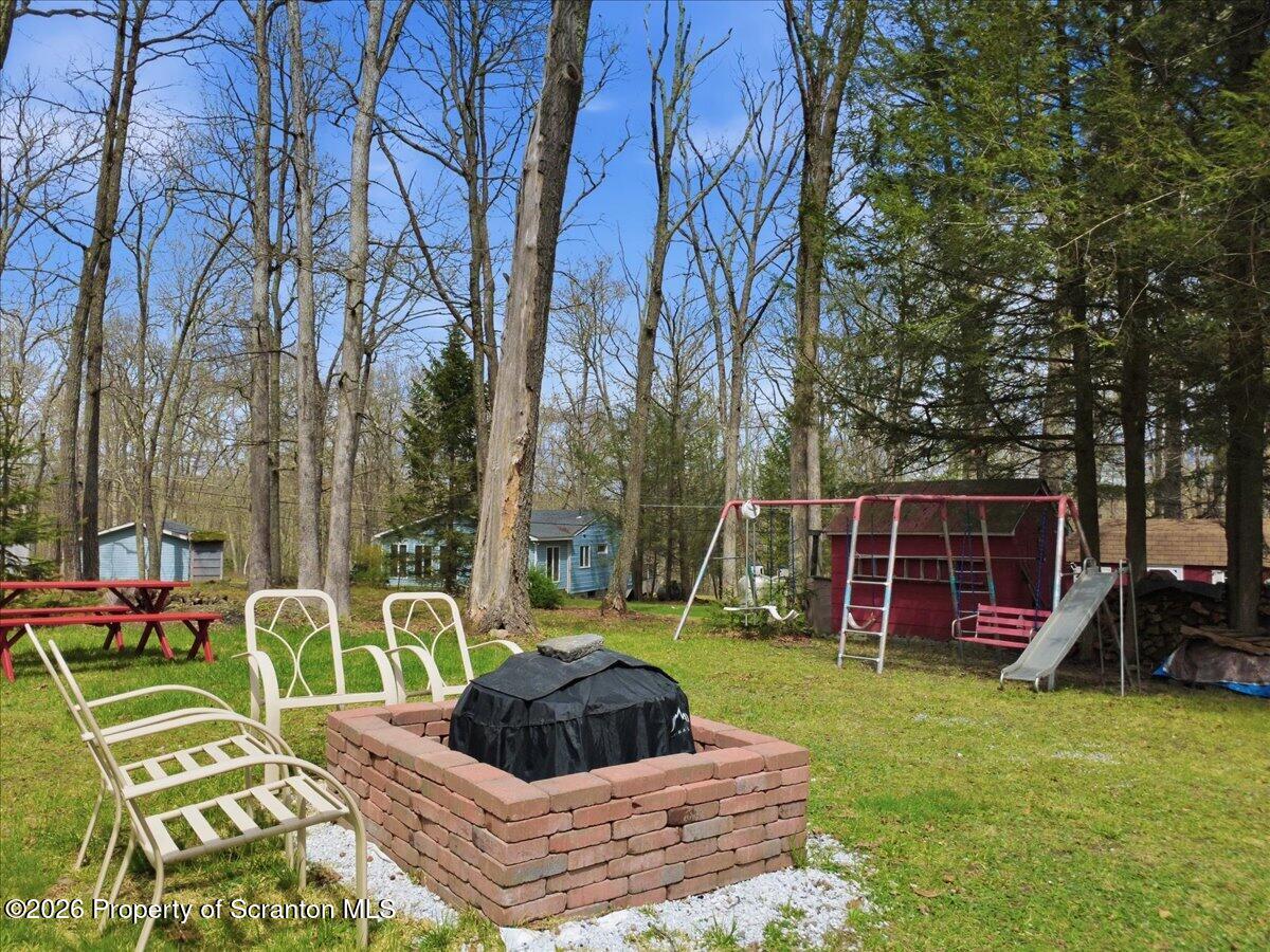 113 Stoney Hill Road Dingmans Ferry, PA 18328 - Photo 52 of 65 a view of a backyard with couches chair and a fire pit