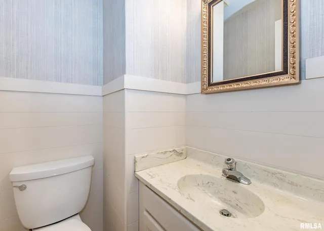 a bathroom with a sink toilet and mirror