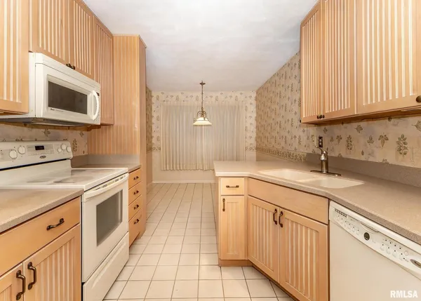a kitchen with white cabinets and white appliances