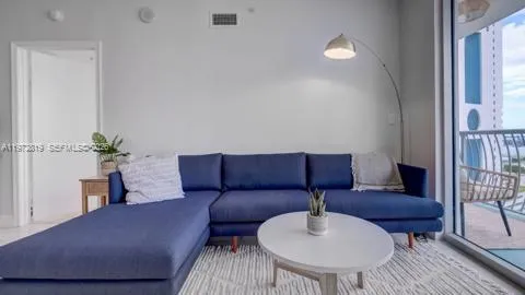 a living room with furniture and a potted plant