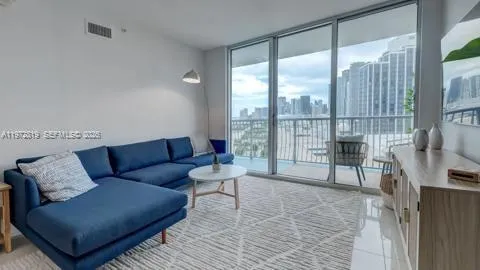 a living room with furniture and a floor to ceiling window