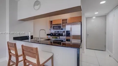 a kitchen with stainless steel appliances granite countertop a sink and a refrigerator