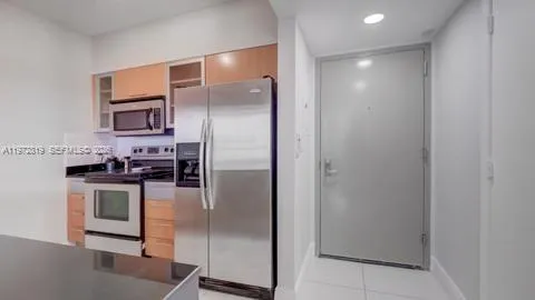 a kitchen with stainless steel appliances granite countertop a refrigerator and a sink