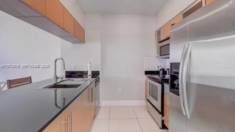 a kitchen with stainless steel appliances granite countertop a refrigerator and a sink