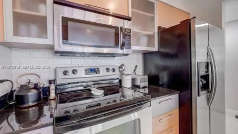 a kitchen with stainless steel appliances granite countertop a stove and a microwave with granite countertops