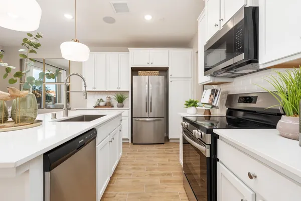 a kitchen with a sink stainless steel appliances and white cabinets