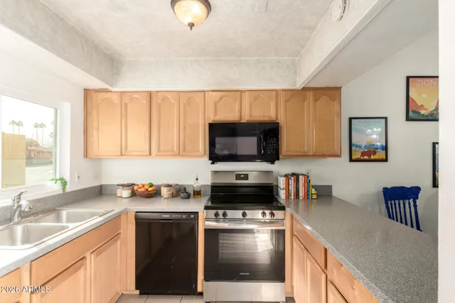 a kitchen with stainless steel appliances a stove sink microwave and cabinets