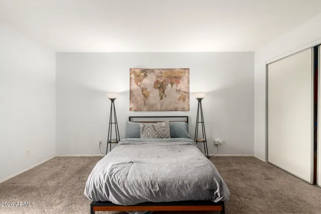 a bedroom with a bed and painting on the wall