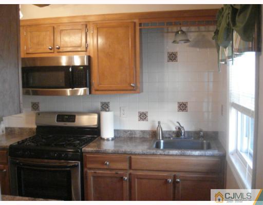 17 Lehigh Road Old Bridge, NJ 08859 - Photo 3 of 10 a kitchen with stainless steel appliances granite countertop a stove and a microwave