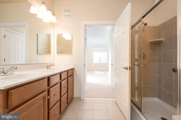 a bathroom with a shower sink and mirror
