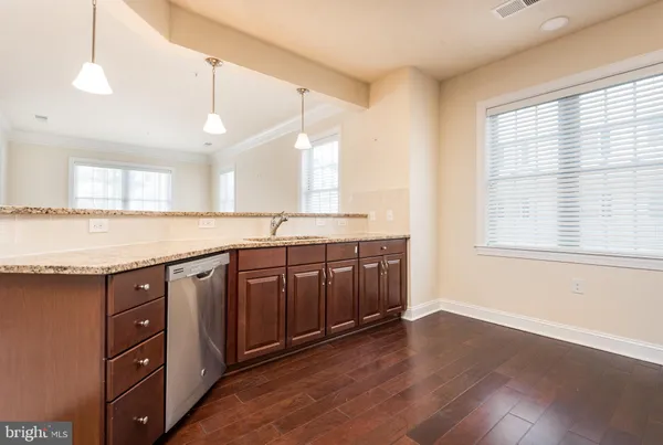 a kitchen with stainless steel appliances granite countertop a sink a stove cabinets and wooden floor