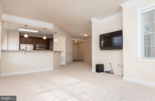 a view of a livingroom with kitchen and a window