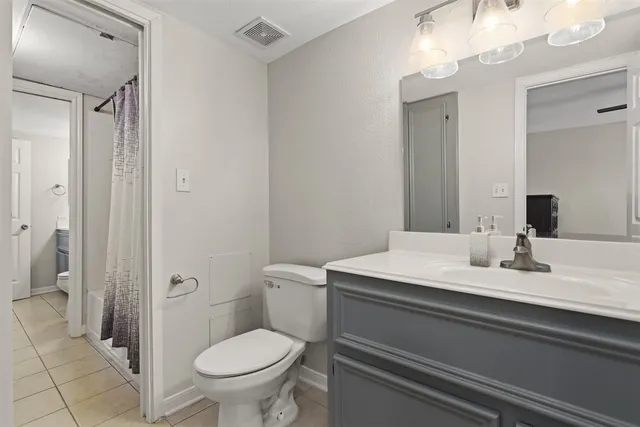 a bathroom with a granite countertop toilet sink and mirror