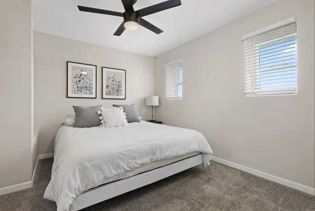 a bedroom with a bed and painting on the wall