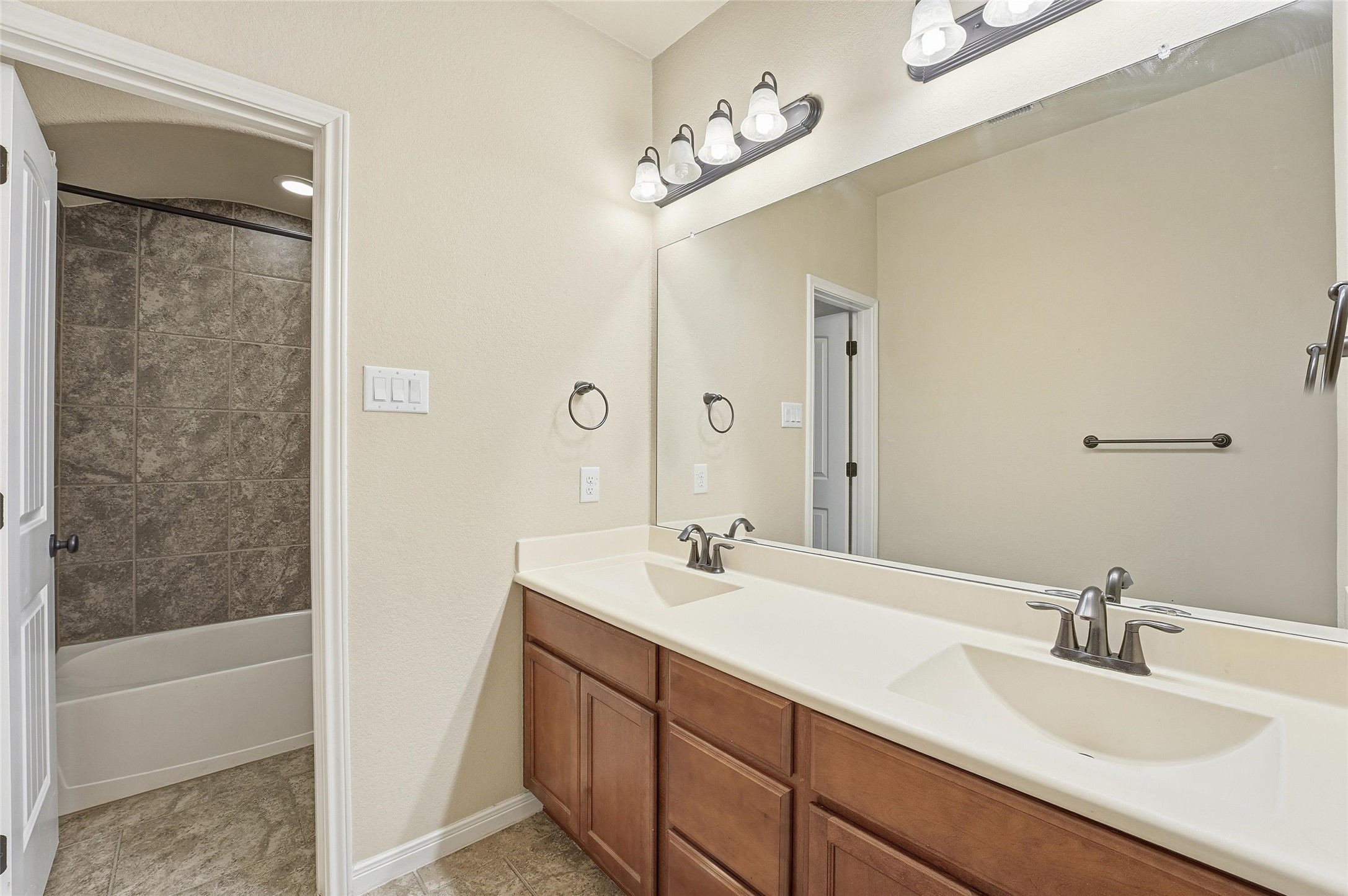 18115 Oliveria Way Houston, TX 77044 - Photo 22 of 32 a bathroom with a double vanity sink a mirror and a bathtub