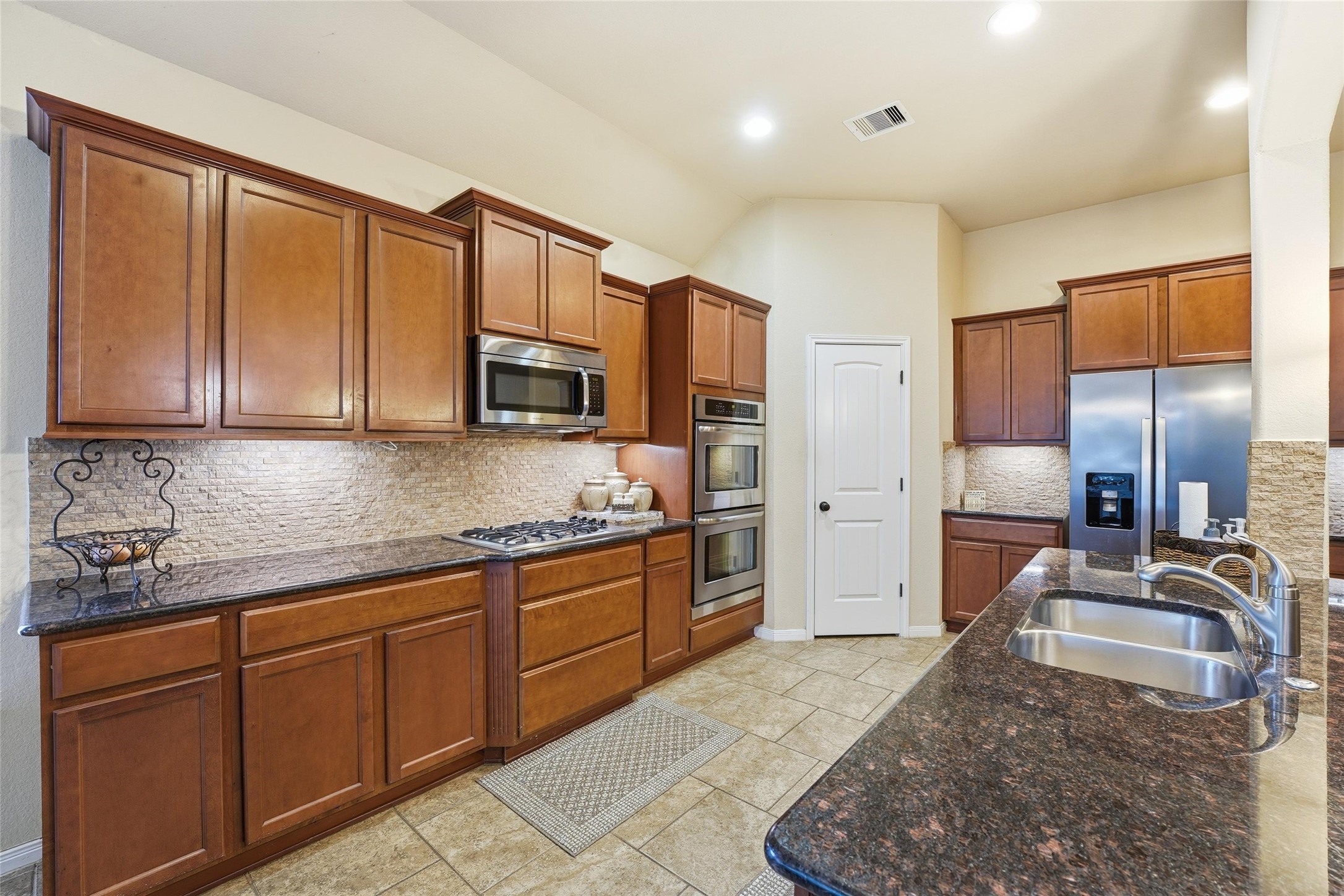 18115 Oliveria Way Houston, TX 77044 - Photo 7 of 32 a large kitchen with stainless steel appliances granite countertop a sink stove and refrigerator