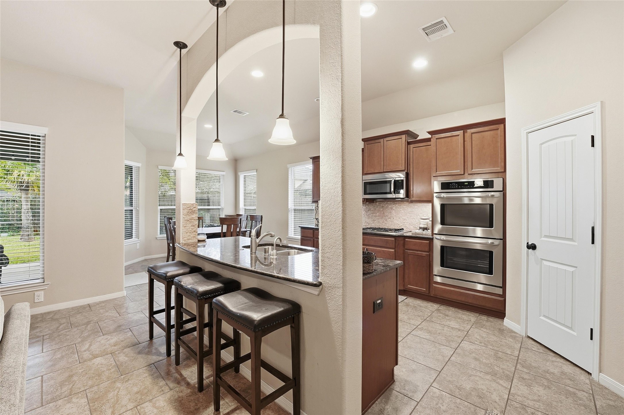 18115 Oliveria Way Houston, TX 77044 - Photo 9 of 32 a kitchen with stainless steel appliances kitchen island granite countertop a refrigerator and a stove top oven
