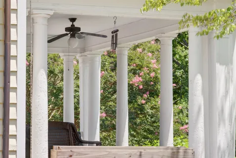 a view of a porch with a floor to ceiling window and wooden floor