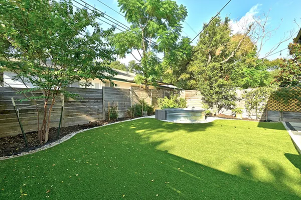 a view of yard with swimming pool and trees in the background